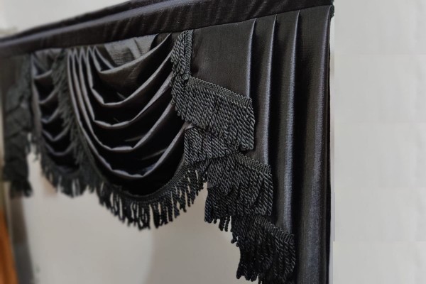 black swag valance with black bullion fringe hanged in room