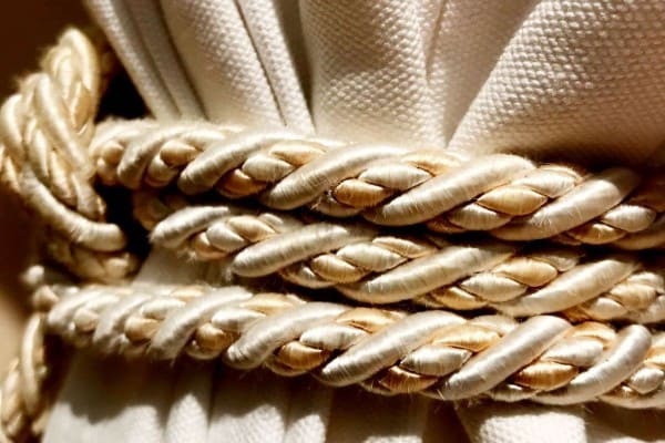 Cream color drapes knot with golden tieback