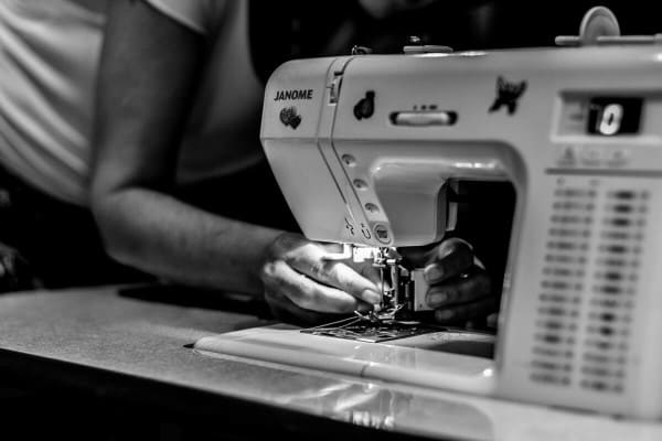 women setting reel to sewing machine